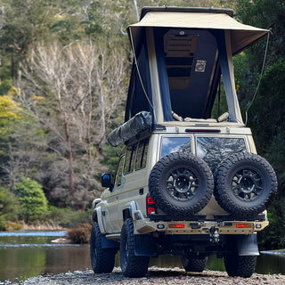 Rear of a 78 Series Troopy with the Headspace roof raised, parked in the bush