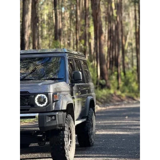 SUV driving on a road surrounded by trees – Headspace Roof Conversion LC76
