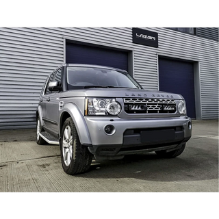 Silver Land Rover parked in front of a building with 'Latan' branding.