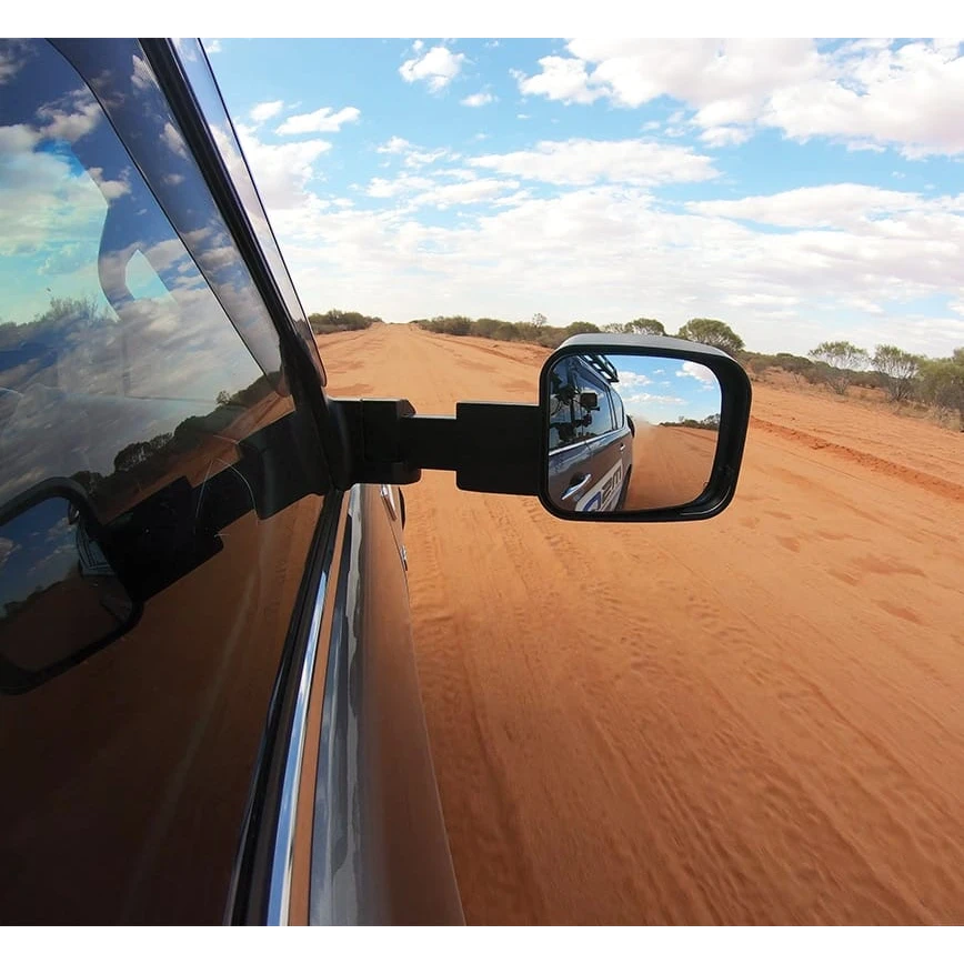 Side view mirror of a vehicle on a desert road with blue sky and clouds – LandCruiser 200 Series MSA POWER FOLD Towing Mirrors