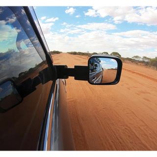 Side view mirror of a vehicle on a desert road with blue sky and clouds – LandCruiser 200 Series MSA POWER FOLD Towing Mirrors