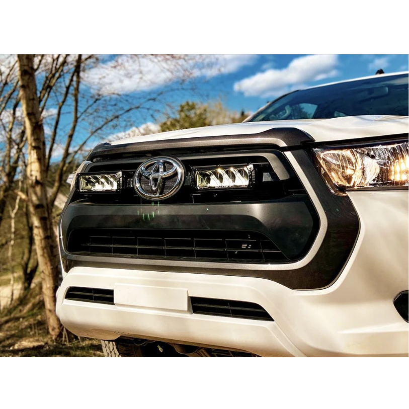 Close-up of a Toyota vehicle's front grille with a blurred natural background