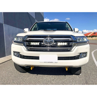 White Toyota 200 series parked on a street with a building in the background with Lazer Lamps Grille Kit – Toyota Land Cruiser 200 Series (2015–2021)