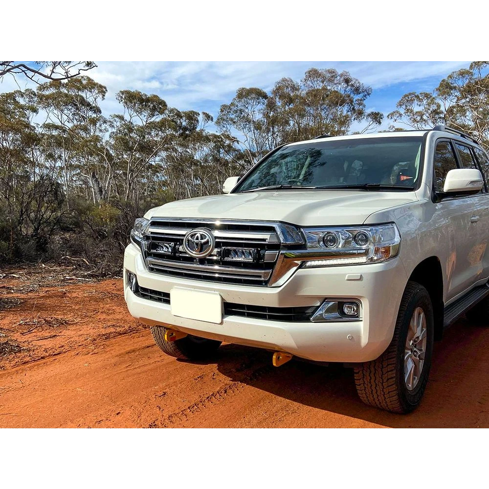 White Toyota SUV on a dirt road with trees in the background