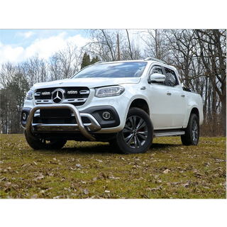 White Mercedes-Benz truck on a grassy field with trees in the background