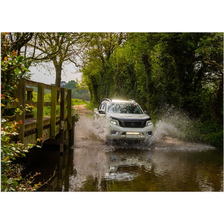 White SUV driving through a shallow stream on a forest road