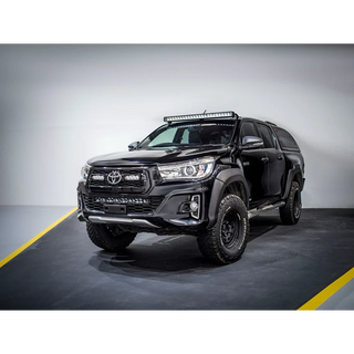 Black Toyota pickup truck with additional lights on a gray background