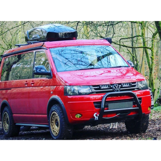 Red Volkswagen van with roof rack in a forest setting with Lazer Lamps Grille Kit for Volkswagen T5.1