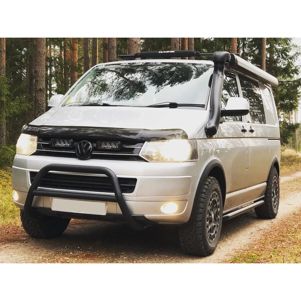 White van with roof rack and off-road bumper in a forest setting