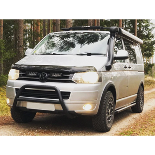White van with roof rack and off-road bumper in a forest setting