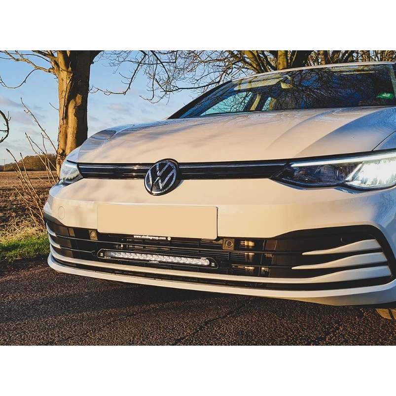 Front view of a white Volkswagen car with a clear sky and tree in the background with Lazer Lamps Grille Kit for VW Golf MK8 (2020–2024)