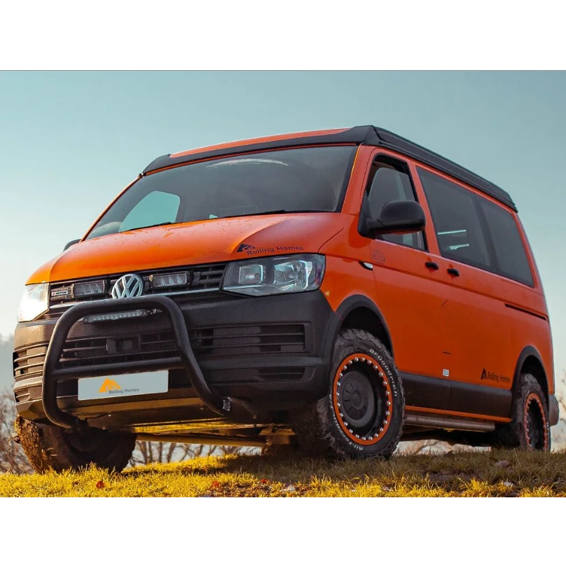 Orange Volkswagen van with off-road modifications on a grassy area with Lazer Lamps Grille Kit for VW Transporter T6 Startline