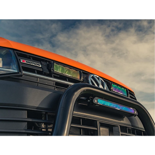Close-up of a vehicle's front grille with 'R-Motion' branding against a cloudy sky.