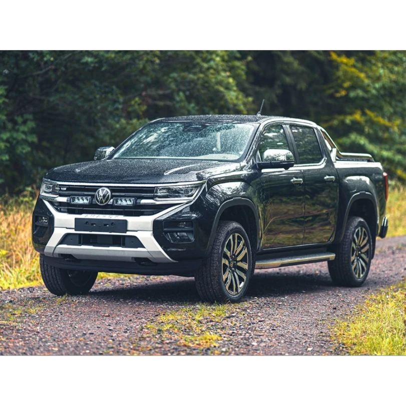 Black Volkswagen pickup truck on a dirt road with greenery in the background with Lazer Lamps Grille Kit for VW Amarok (2023+)