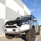 Toyota SUV with off-road modifications parked on a road with a building and blue sky in the background with Lazer Lamps Grille Kit – Toyota Land Cruiser 200 Series (2015–2021)