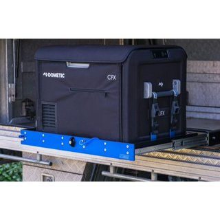 Line drawing of a fridge strapped to an MSA slide seen from the front three-quarter, showing the tall strap posts, the vented compressor end of the fridge and the slide extended clear of its mount