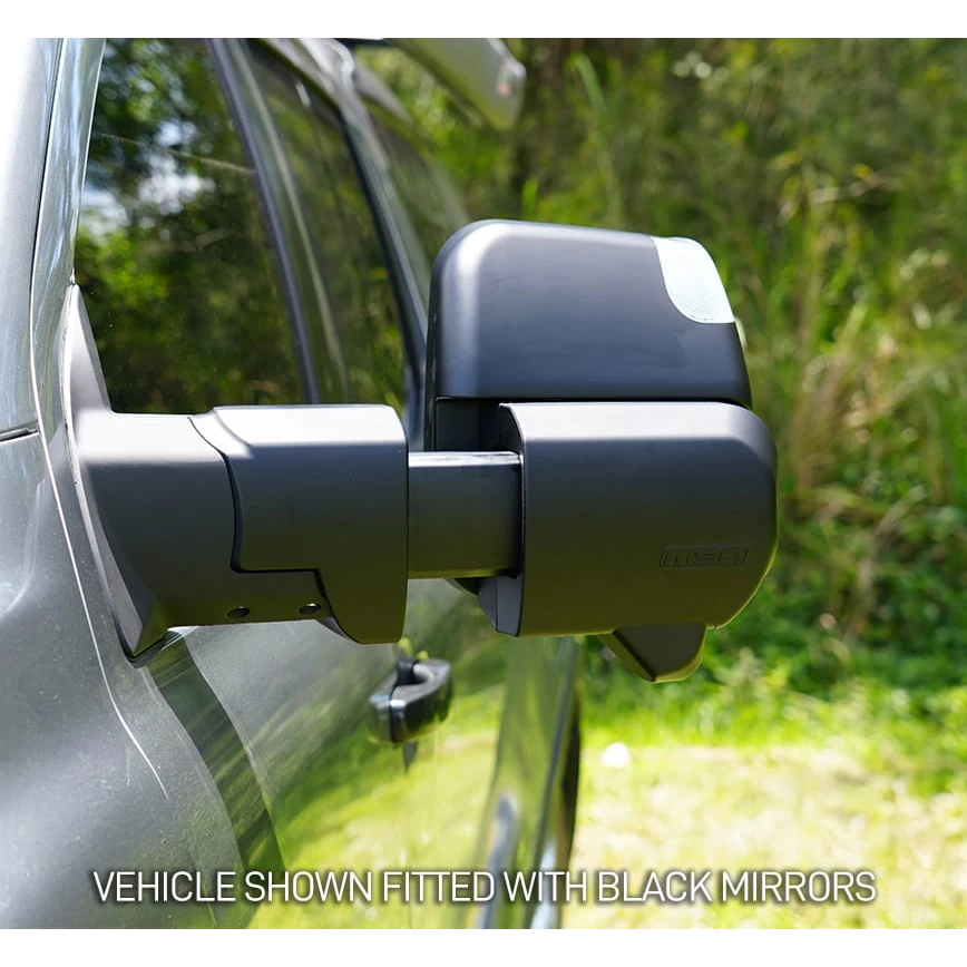 Close-up of a vehicle with black side mirrors against a natural background