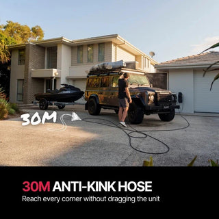 Person using a long hose to clean a vehicle in front of a house – Blahst R30 Wall-Mounted Pressure Washer