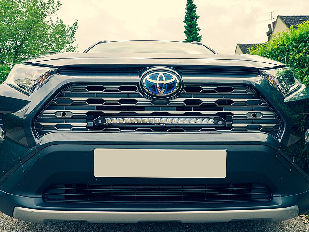 Close-up of a Toyota RAV4 car grille with logo
