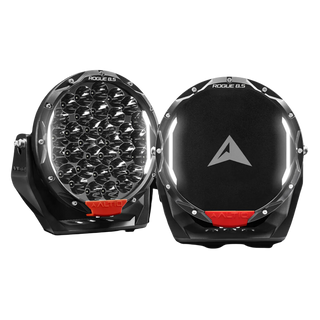 A pair of ALTIQ Rogue 8.5 driving lights side by side, one showing the reflector face with its dense cluster of LEDs and the ROGUE 8.5 marking on the bezel, the other fitted with a black cover carrying the ALTIQ arrow, both with red ALTIQ trim tabs at the base