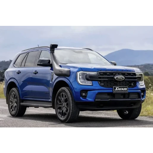 Blue Ford Safari SUV on a road with mountains in the background
