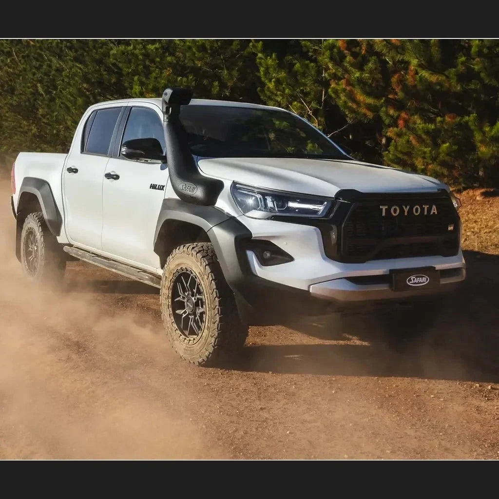 White Toyota Hilux with Safari Armax snorkel driving on a dirt road