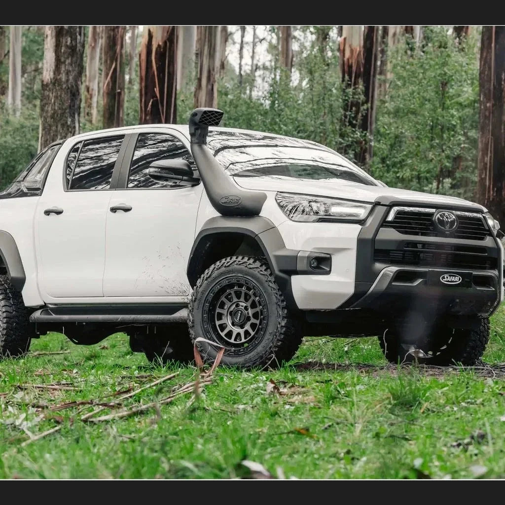 White Toyota Hilux Rogue with Safari flare kit and Armax snorkel in a forest setting