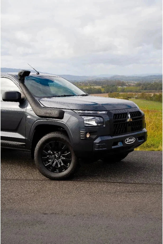 Black SUV parked on a road with a scenic background