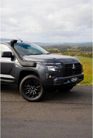 Black SUV parked on a road with a scenic background