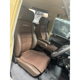 Interior of a vehicle with brown seats and visible branding – Scheelmann Traveller Seat with Armrest