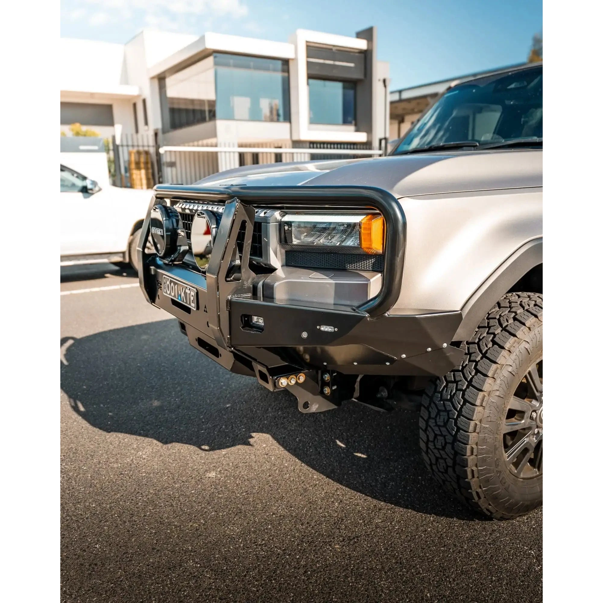Silver SUV with a front bumper in an urban setting – TCC 250 Prado Bull Bar