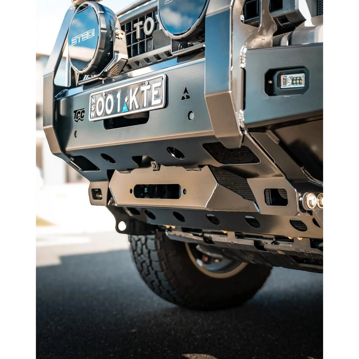 Close-up of a vehicle's front bumper with visible branding and license plate – TCC 250 Prado Bull Bar
