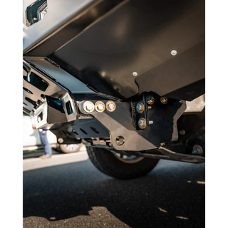 Close-up of a vehicle's undercarriage with visible suspension components on a road – TCC 250 Prado Bull Bar