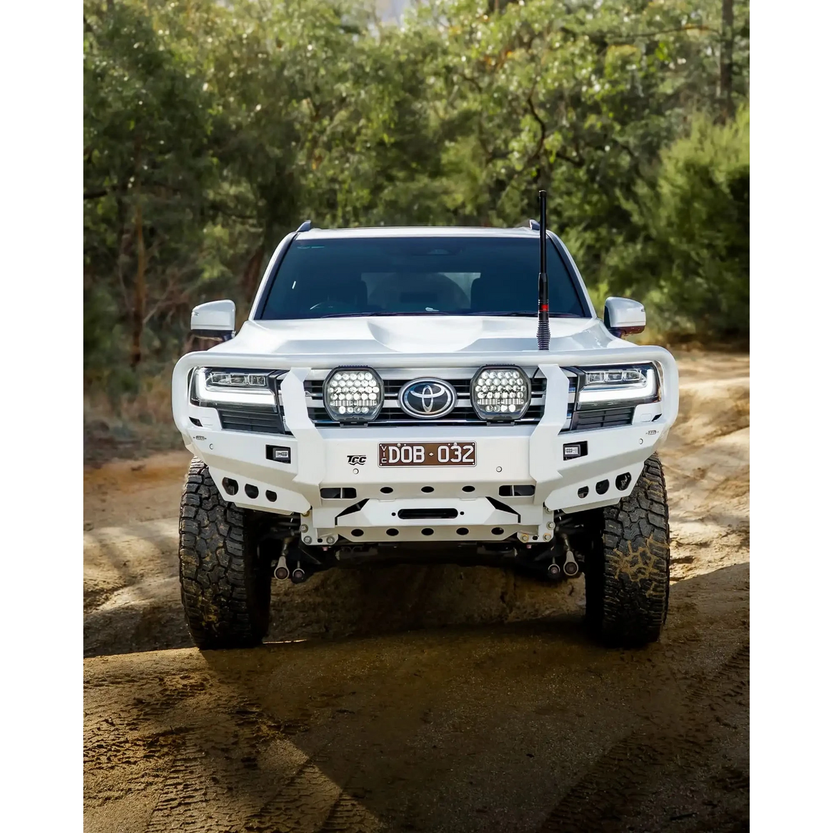 White Toyota SUV on a dirt road with trees in the background – TCC Toyota LandCruiser 300 Series Bull Bar