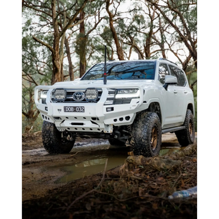 White Toyota SUV driving through a forest on a muddy path – TCC Toyota LandCruiser 300 Series Bull Bar