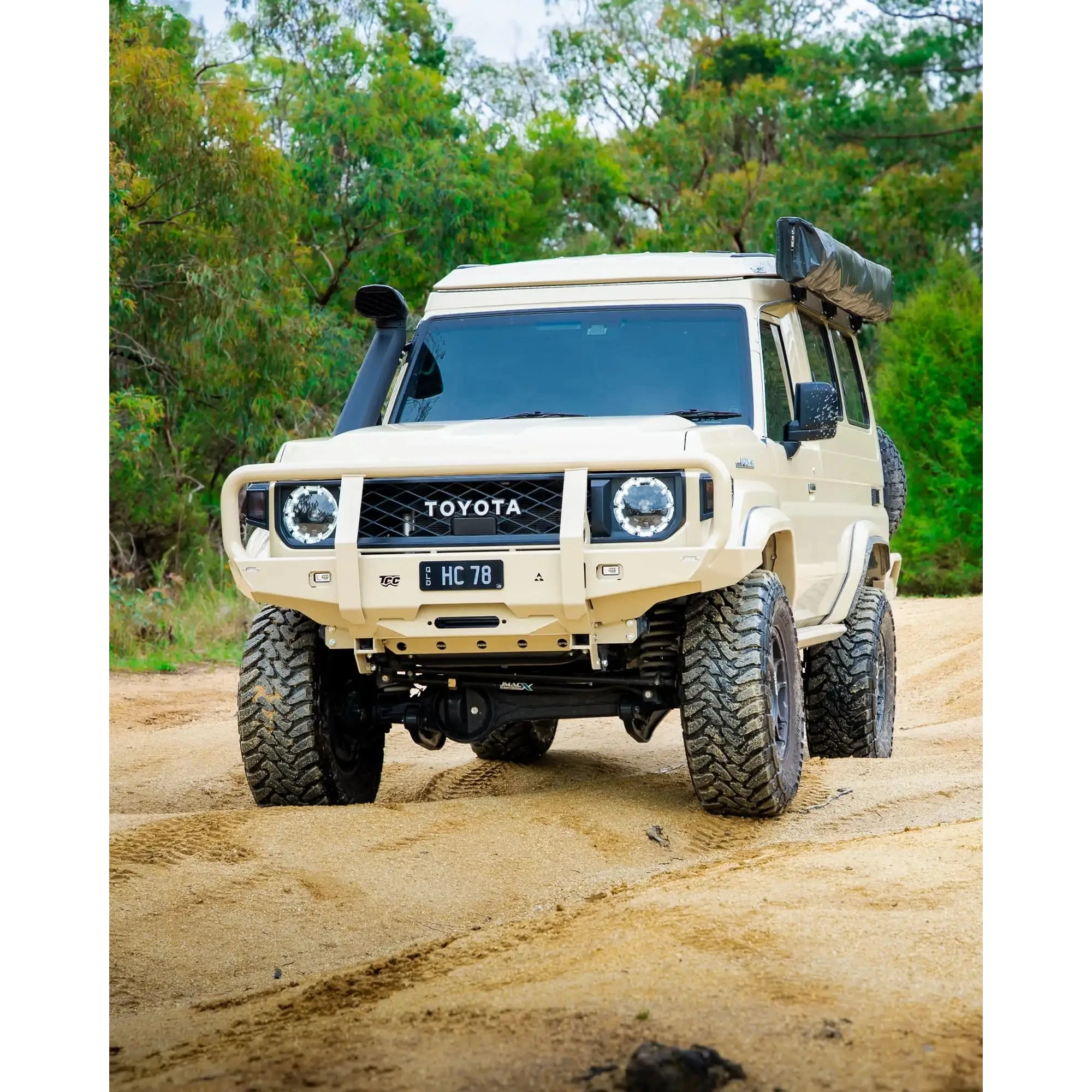 Toyota off-road vehicle on a dirt road with trees in the background – TCC 70 Series Bull Bar - Facelift (2024 - Present)