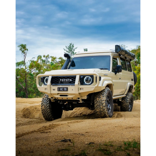 sandy Toyota off-road vehicle on a dirt road with trees in the background – TCC 70 Series Bull Bar - Facelift (2024 - Present)