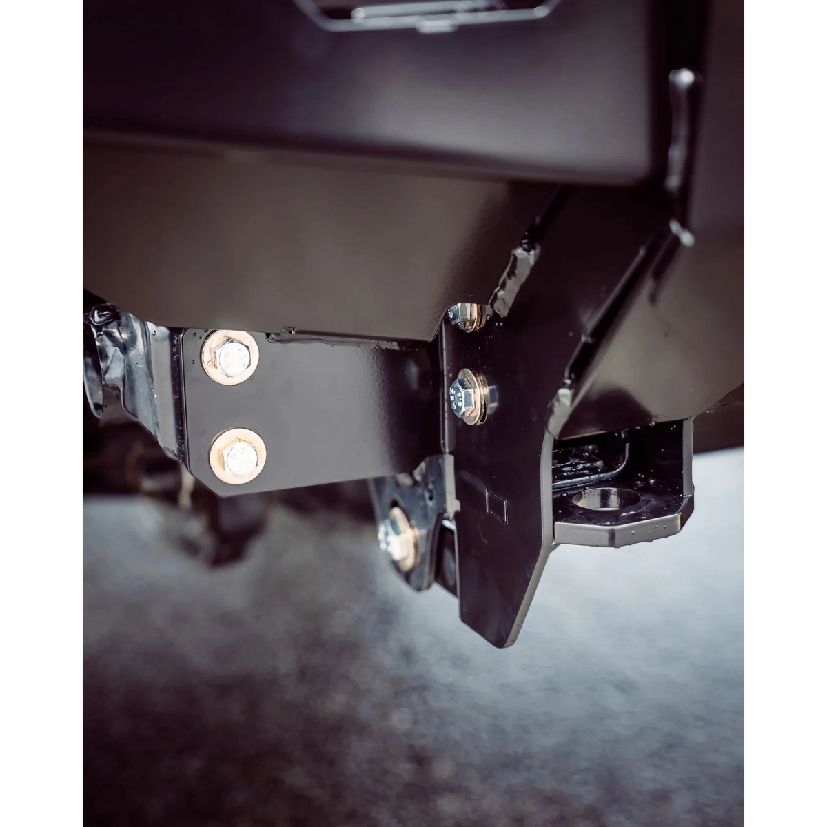 Close-up of a metal bracket with screws on a dark background – TCC 70 Series Single Cab Bull Bar - Facelift (2024 - Present)