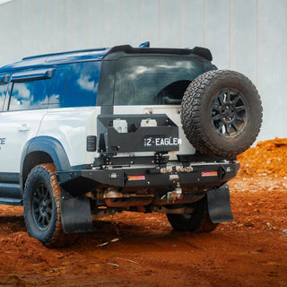 Off-road vehicle with large tire and additional wheel on a dirt surface – TCC Land Rover Defender 2020+ Rear Bar