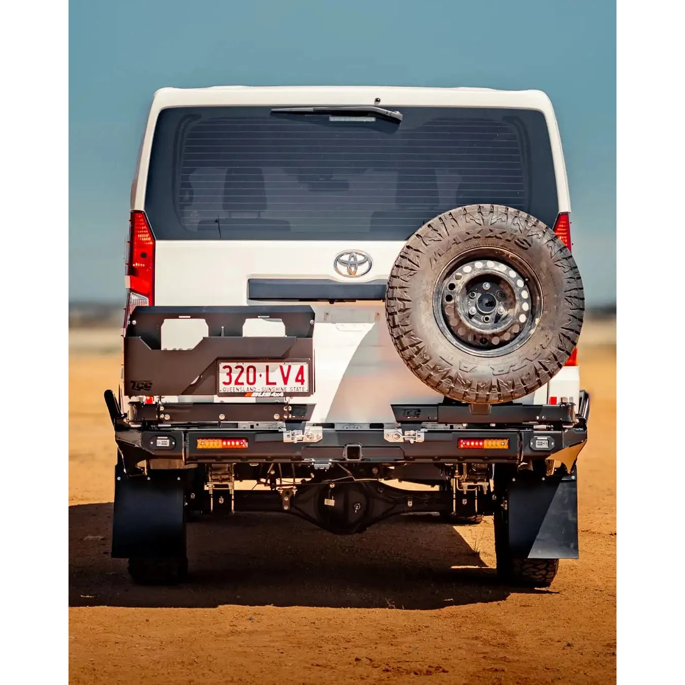 Back view of a white Toyota vehicle with a spare tire on a desert landscape – TCC Toyota Hiace 300 Series Rear Bar