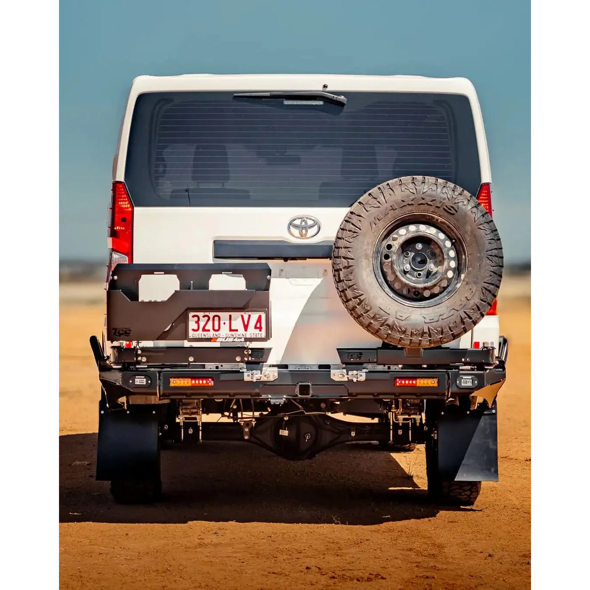 Back view of a white Toyota vehicle with a spare tire on a desert landscape – TCC Toyota Hiace 300 Series Rear Bar