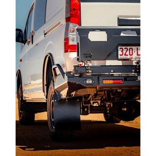 Close-up of a white van's rear with a black bumper on a dirt road – TCC Toyota Hiace 300 Series Rear Bar