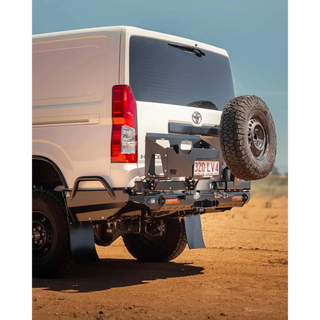 White van with a spare tire mounted on the back in a desert setting – TCC Toyota Hiace 300 Series Rear Bar