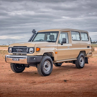 Beige Toyota Land Cruiser in a desert landscape with a cloudy sky – TCC Toyota LC78 Troopcarrier Side Steps