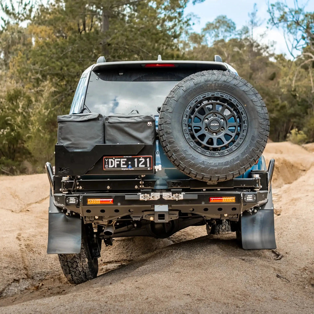 Off-road vehicle with spare tire and additional equipment on a dirt road – TCC Toyota Prado 250 Series Rear Bar