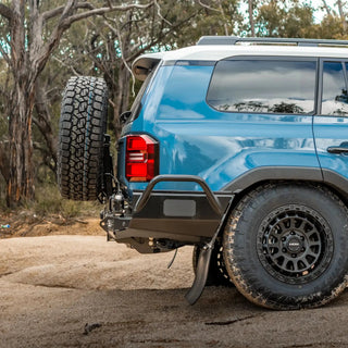 Blue SUV with off-road tires and bumper in a natural setting – TCC Toyota Prado 250 Series Rear Bar