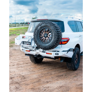White SUV with spare tire mounted on a dirt road – TCC Y62 Patrol Rear Bar