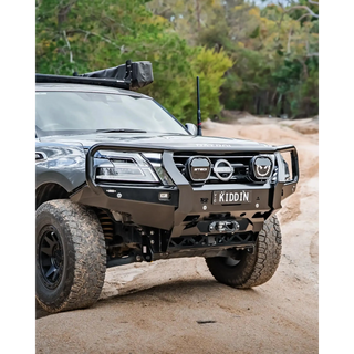 Off-road vehicle on a dirt road with trees in the background – TCC Y62 Patrol S5 Bull Bar