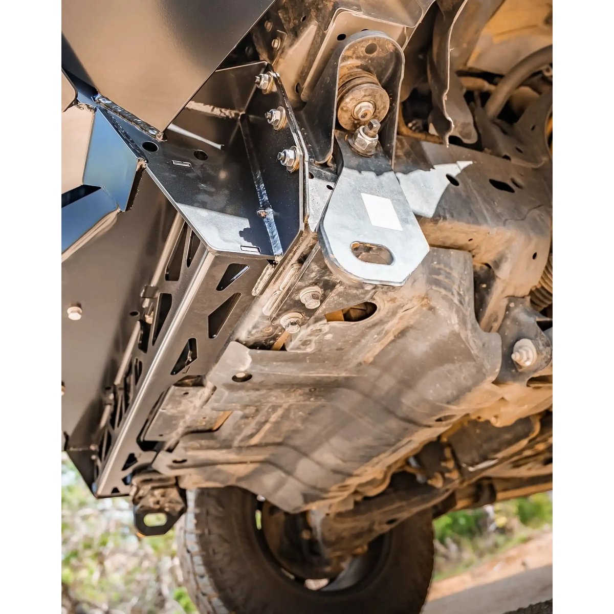 Close-up of a vehicle's undercarriage with suspension components – TCC Y62 Patrol S5 Bull Bar