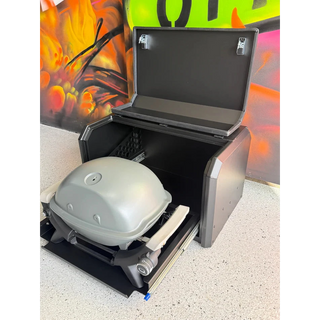 Thorburns BBQ 2.0 Accessory – black barbecue grill with a lid open, showing a portable barbecue inside, against a colourful abstract background.